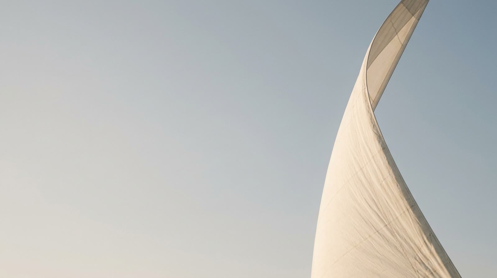 A sail against a pale sky, seen from below